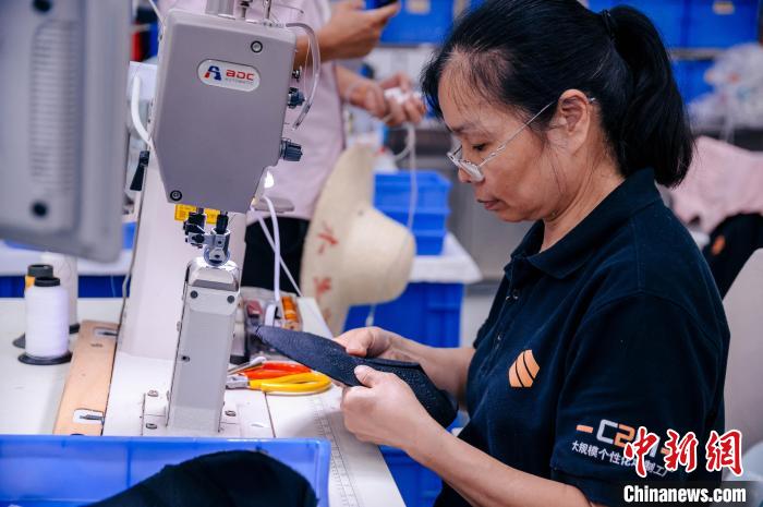 圖為員工在生產(chǎn)線(xiàn)工作?！±钅宪?攝