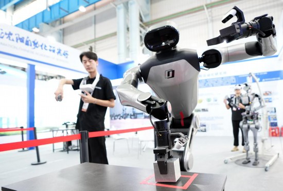 9月5日，在沈陽的2025全球工業(yè)互聯(lián)網(wǎng)大會的展覽區(qū)現(xiàn)場，中國科學(xué)院沈陽自動化研究所的機器人工程師在調(diào)試具身智能操作系統(tǒng)。新華社記者 李鋼 攝