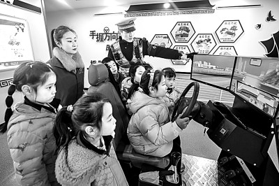 山東省榮成市公安局道路交通安全宣傳教育基地，交警帶領(lǐng)小學(xué)生現(xiàn)場體驗?zāi)M駕駛。新華社發(fā)