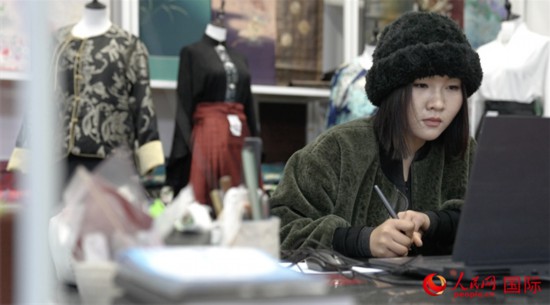 1月23日,在山東省菏澤市曹縣有愛(ài)云倉(cāng)直播基地,張子晨正在設(shè)計(jì)漢服。 人民網(wǎng)記者 袁蒙攝