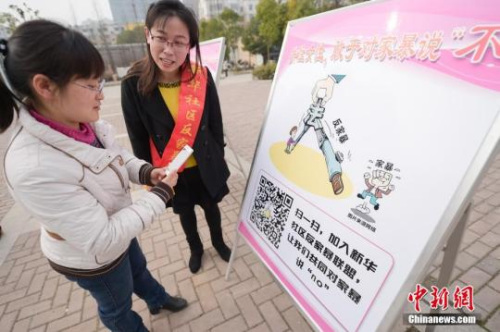 資料圖：今年3月8日，安徽合肥新華社區(qū)志愿者夏一瓊(右)向市民普及反家暴相關(guān)法律知識(shí)。鐘欣 攝