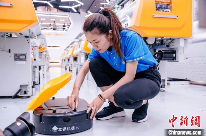 圖為員工在調(diào)試AGV搬運(yùn)機(jī)器人?！±钅宪?攝