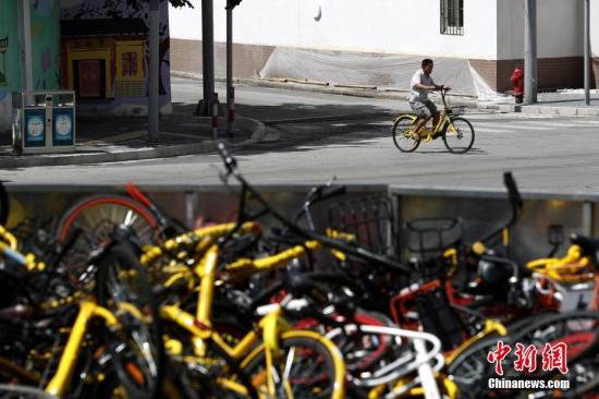 上?，F(xiàn)共享單車“墳?zāi)埂?堆積如山場面壯觀。 張亨偉 攝